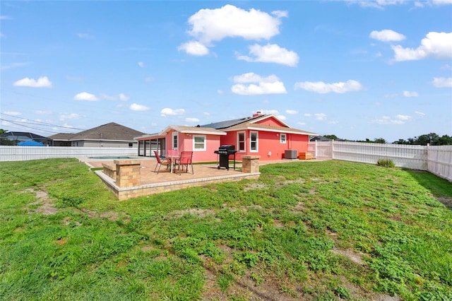 402 SW Seaflower Ter, Port St Lucie, FL 34984 - back of house with roof mounted solar panels, a fenced backyard, and a patio area