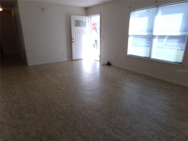 unfurnished room featuring tile flooring and a wealth of natural light