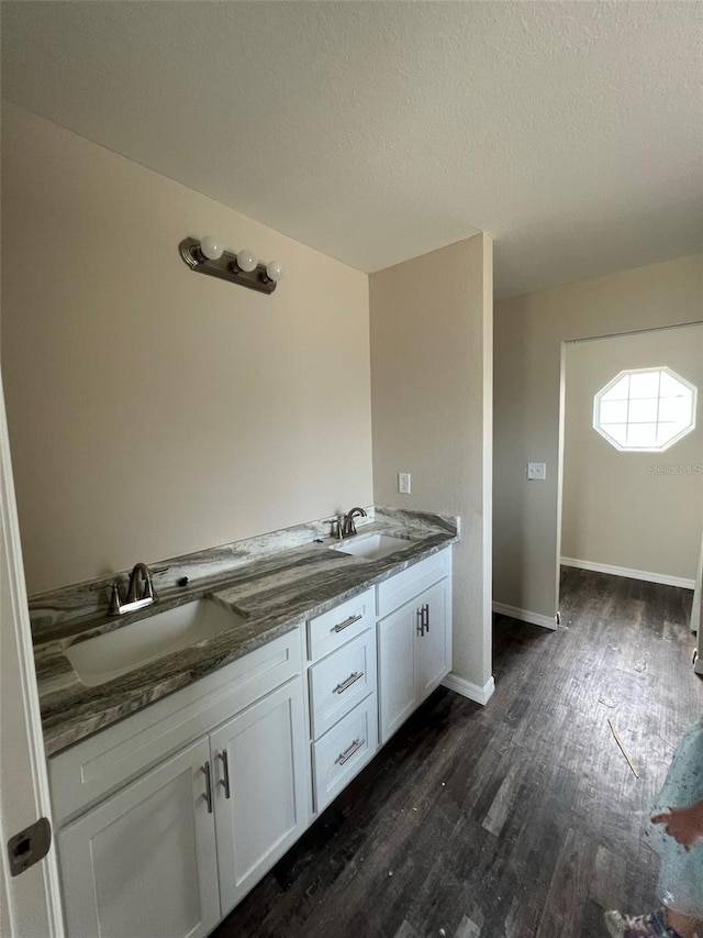 bathroom featuring double sink vanity, hardwood / wood-style flooring, and a textured ceiling