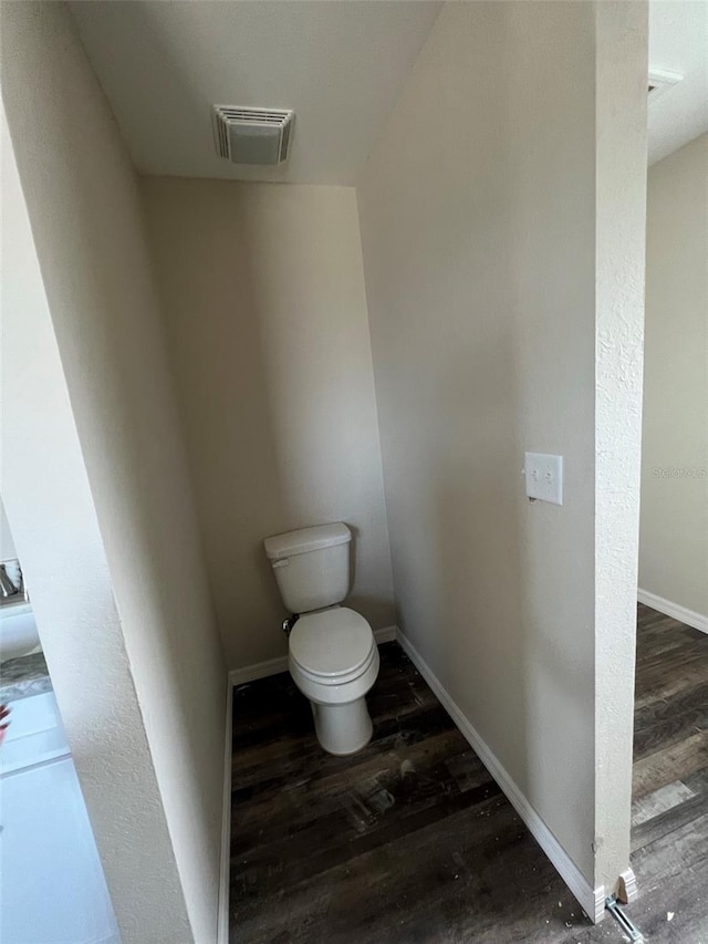 bathroom with toilet and hardwood / wood-style flooring