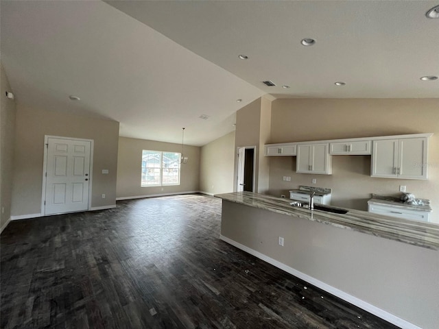 kitchen with white cabinetry, high vaulted ceiling, sink, a chandelier, and dark hardwood / wood-style flooring