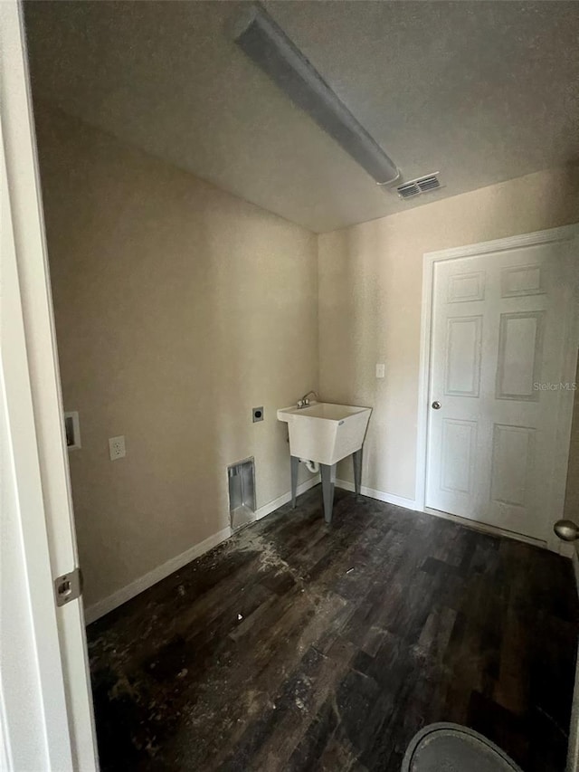 clothes washing area with sink, dark hardwood / wood-style floors, and hookup for an electric dryer