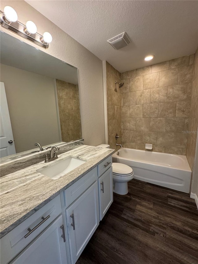 6711 SW 64th Ave, Ocala, FL 34476 - bathroom featuring wood finished floors, visible vents, toilet, a textured ceiling, and bathtub / shower combination