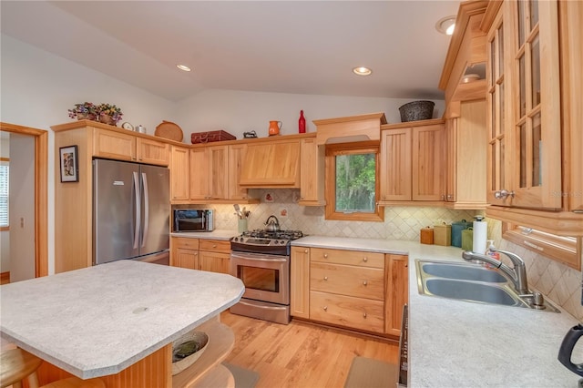 kitchen with lofted ceiling, tasteful backsplash, sink, and stainless steel appliances