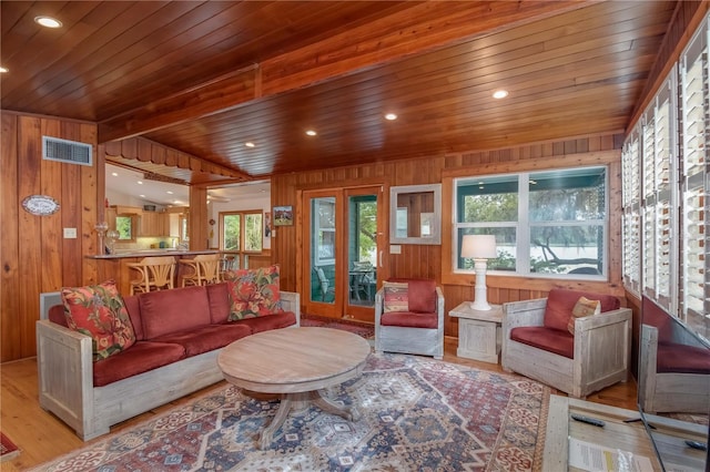 living room featuring wooden walls, light hardwood / wood-style floors, and wooden ceiling