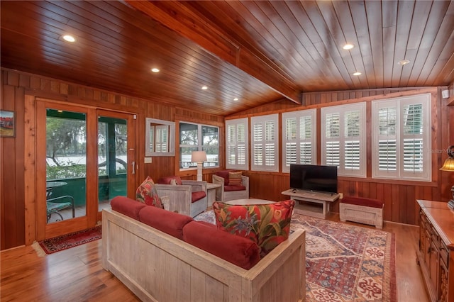 living room with wooden walls, vaulted ceiling with beams, wooden ceiling, and light hardwood / wood-style flooring