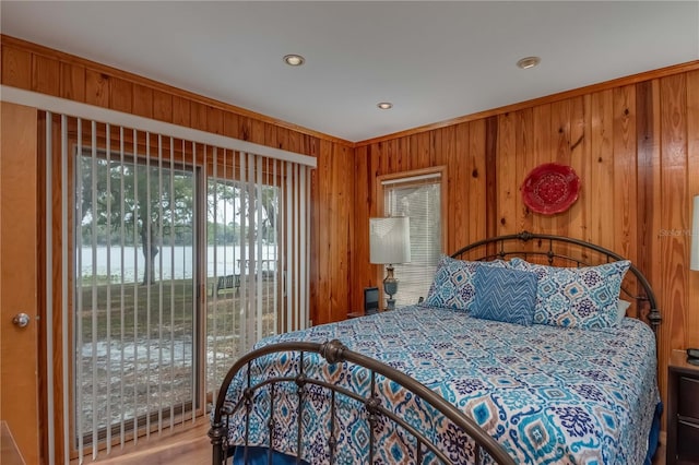 bedroom with access to exterior and wooden walls