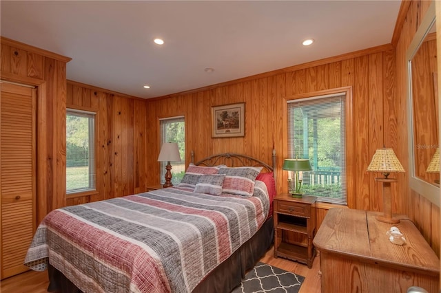 bedroom featuring wood walls and light hardwood / wood-style floors