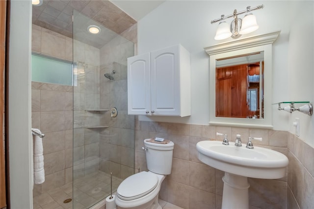 bathroom featuring backsplash, a shower with shower door, toilet, and tile walls