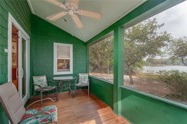 sunroom / solarium with a water view, vaulted ceiling, and ceiling fan