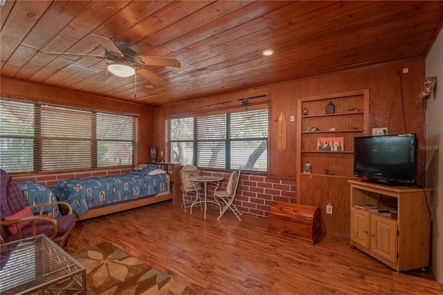 bedroom with wood ceiling, wooden walls, ceiling fan, and light wood-type flooring