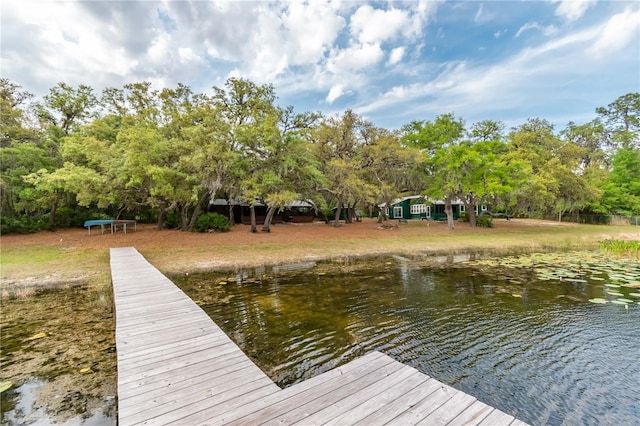 view of dock with a water view and a yard