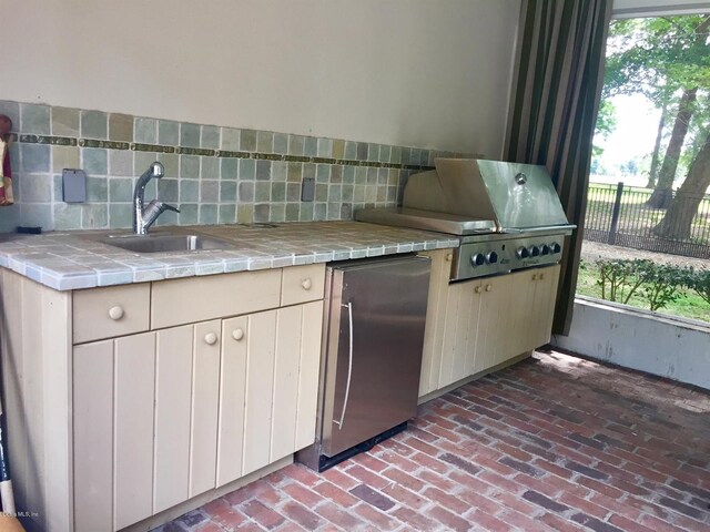 kitchen featuring plenty of natural light, tasteful backsplash, and fridge