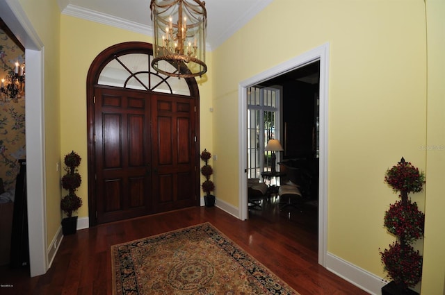 foyer entrance with an inviting chandelier, crown molding, and dark hardwood / wood-style floors