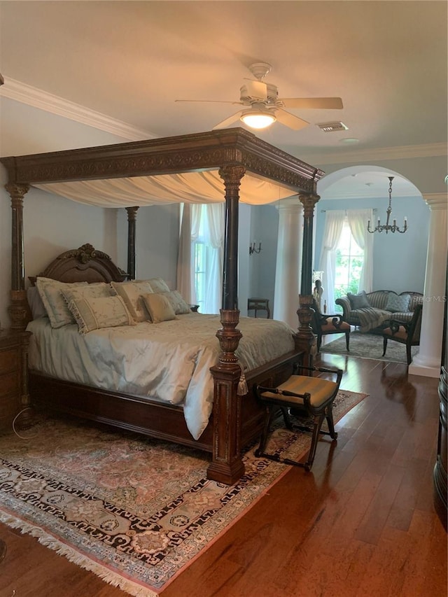 bedroom featuring dark hardwood / wood-style floors, decorative columns, and ornamental molding