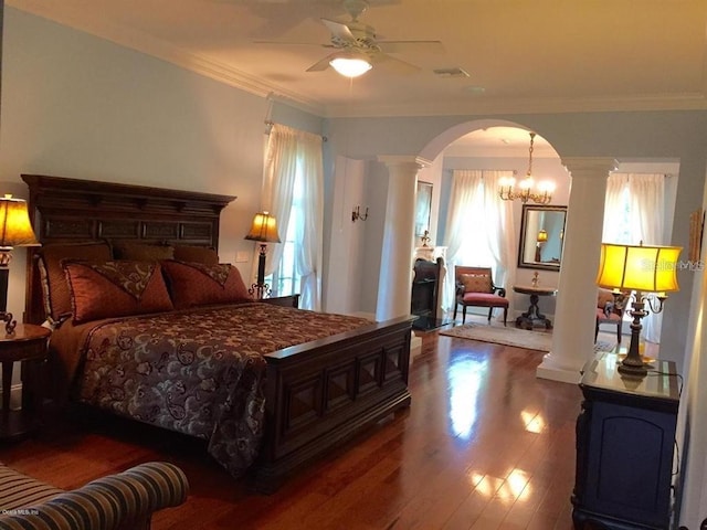 bedroom featuring crown molding, dark hardwood / wood-style floors, an inviting chandelier, and ornate columns