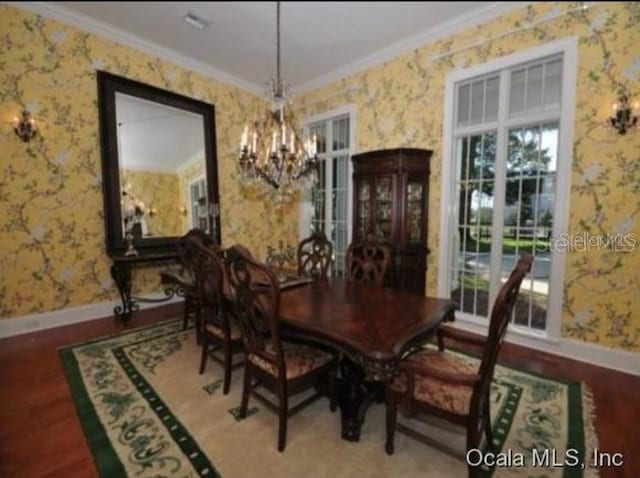 dining area featuring plenty of natural light, a chandelier, crown molding, and hardwood / wood-style flooring