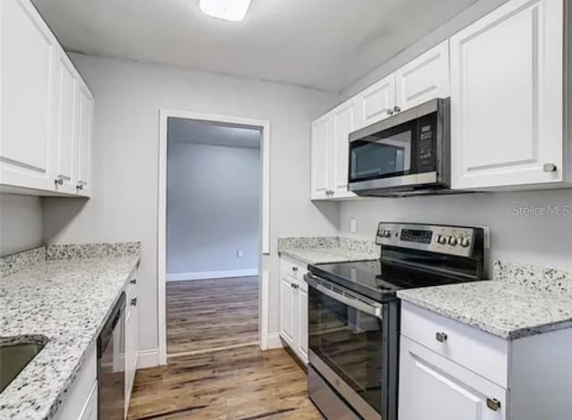 kitchen featuring light stone counters, stainless steel appliances, wood-type flooring, and white cabinetry