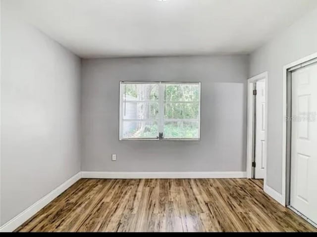 unfurnished room with wood-type flooring