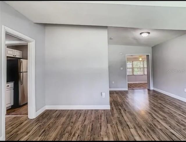 unfurnished room featuring dark wood-type flooring