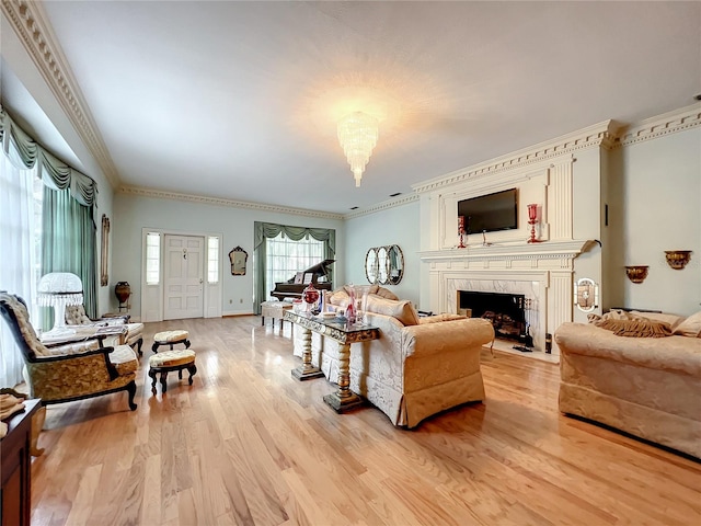 living room with crown molding, light hardwood / wood-style floors, and a fireplace