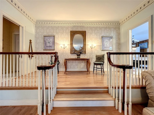 staircase with ornamental molding and light hardwood / wood-style flooring