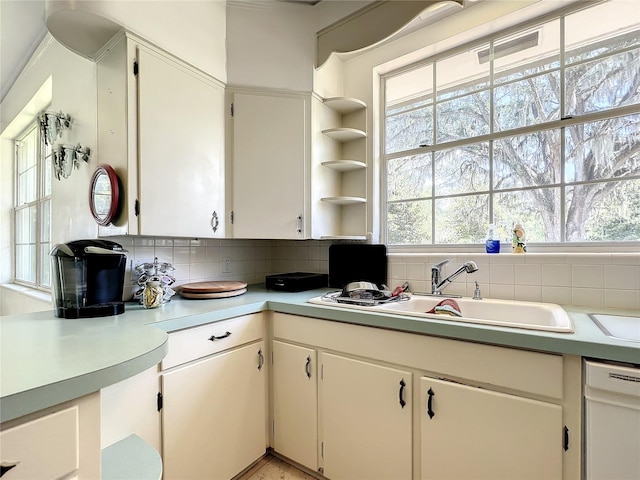 kitchen featuring backsplash, white cabinetry, dishwasher, and sink