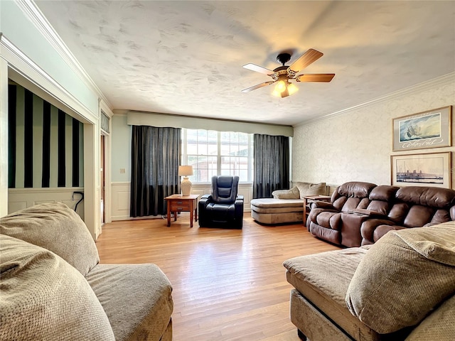 living room with ceiling fan, light wood-type flooring, and crown molding