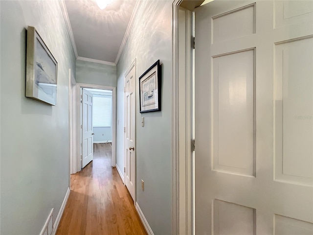 corridor featuring light hardwood / wood-style flooring and crown molding