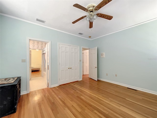 unfurnished bedroom with crown molding, ceiling fan, and light wood-type flooring