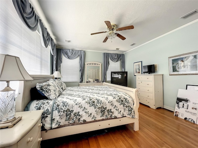 bedroom featuring ceiling fan, hardwood / wood-style flooring, and ornamental molding