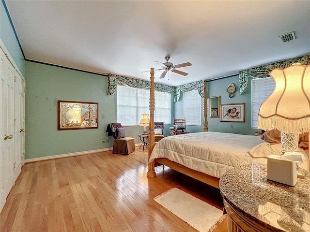 bedroom with crown molding, light hardwood / wood-style floors, and ceiling fan