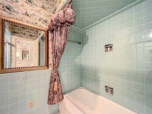 bathroom with tile walls and tiled shower / bath