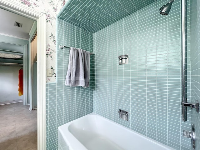 bathroom featuring tile floors and tiled shower / bath