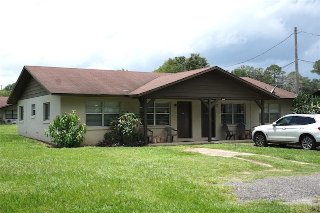 ranch-style home featuring covered porch and a front lawn