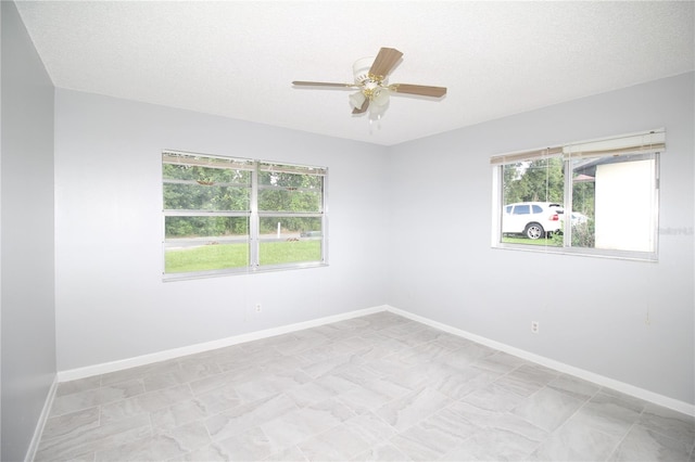 empty room with a textured ceiling and ceiling fan