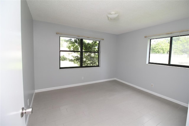 unfurnished room featuring a textured ceiling