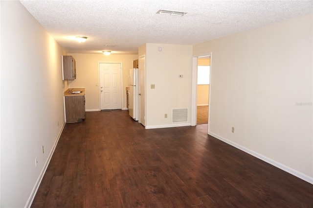 spare room with dark hardwood / wood-style flooring and a textured ceiling