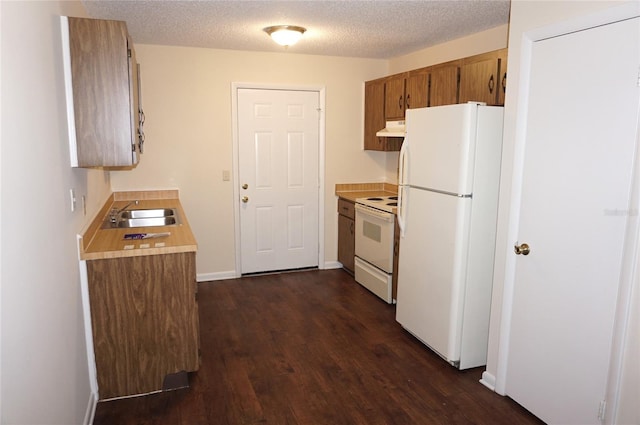 kitchen with a textured ceiling, sink, dark wood-type flooring, and white appliances