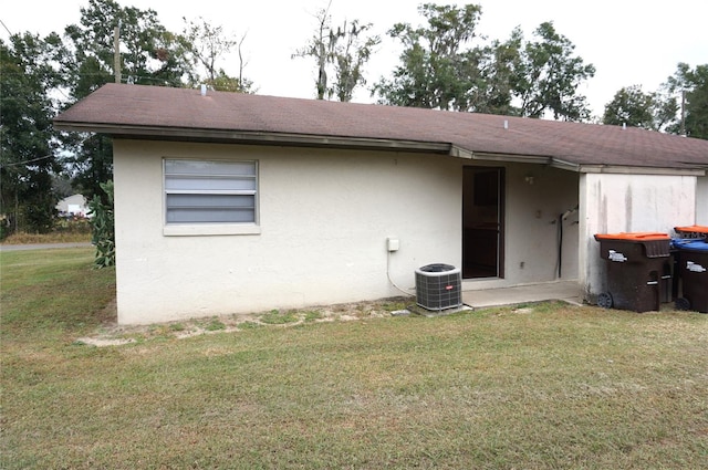 rear view of house featuring a yard and central air condition unit