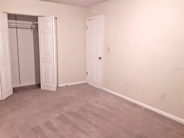 unfurnished bedroom with a closet and dark colored carpet