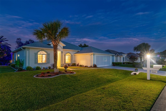 ranch-style home with a yard and a garage