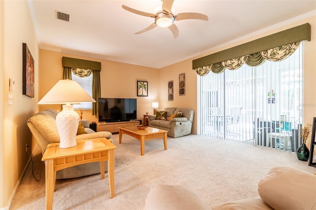 carpeted living room featuring ceiling fan and crown molding