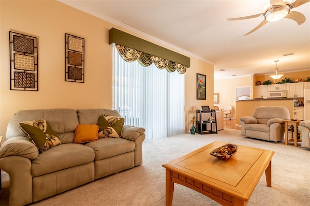 carpeted living room with crown molding and ceiling fan