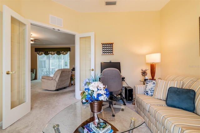 living room featuring light carpet, french doors, and ceiling fan