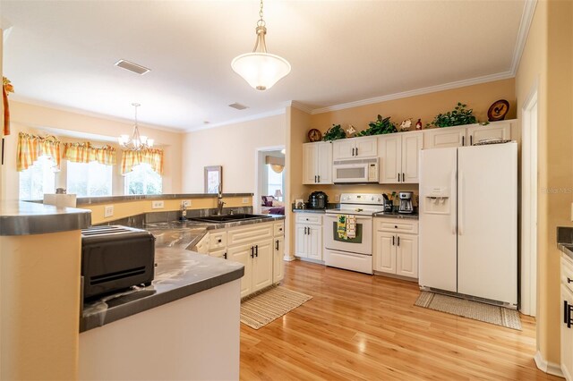 kitchen with decorative light fixtures, white appliances, light wood-type flooring, and an inviting chandelier