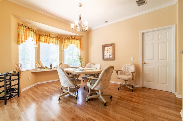 dining room featuring crown molding, light hardwood / wood-style floors, and an inviting chandelier