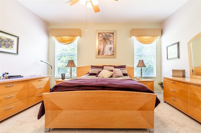 bedroom with light colored carpet, ceiling fan, and multiple windows