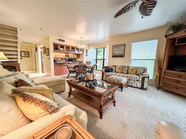 living room featuring carpet flooring and an inviting chandelier