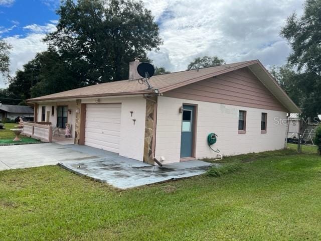 back of house featuring a garage and a yard